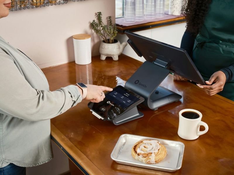 Cliente pagando en el TPV del mostrador de una cafetería